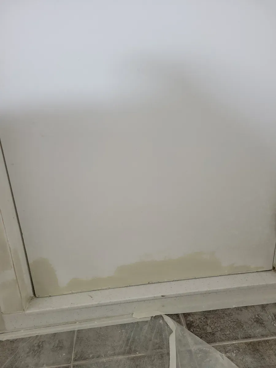 하단이 누렇게 변색된 화장실 문과 타일 바닥 경계
